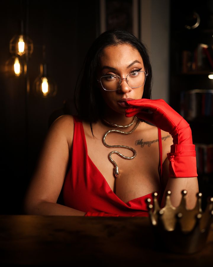Hazel in red gloves at her desk beside a gold crown